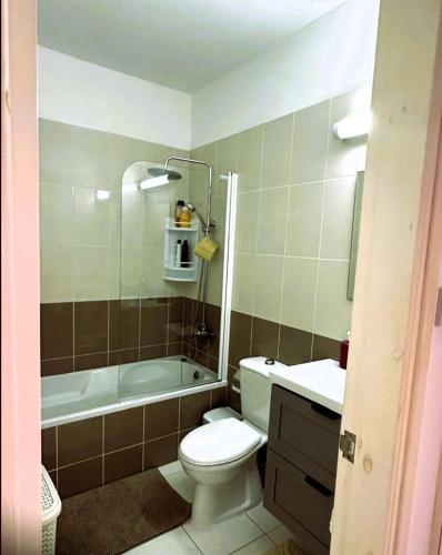 a bathroom with a toilet and a tub and a sink at Peyia Spring in Peyia