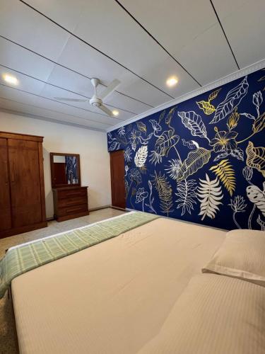 a bedroom with a bed and a blue wall at Villa La Mama Beruwala in Beruwala