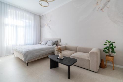 a white living room with a couch and a table at Palmotić Heritage Suites - Main Square - FREE Parking in Zagreb