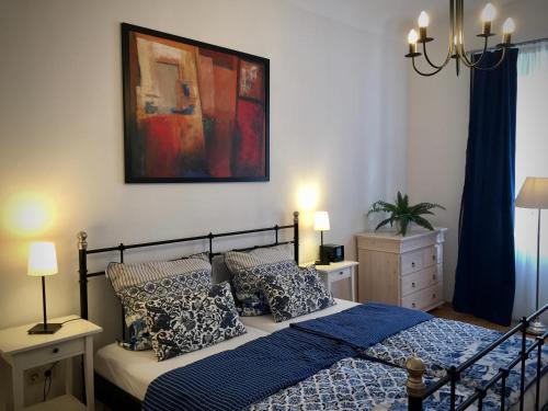 Schlafzimmer mit einem Bett mit blauer Bettwäsche und Kissen in der Unterkunft Ihr Domizil auf Zeit in Würzburg in Würzburg