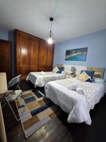 a hotel room with two beds and a table at O Parrandeiro in Padrón