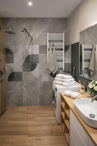 a bathroom with a washing machine and a sink at APART FLOW Walendów Park in Nadarzyn