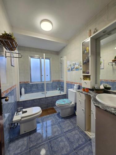 a bathroom with two sinks and a toilet and a tub at O Parrandeiro in Padrón