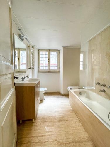a large bathroom with two sinks and a tub and a toilet at La Pigna Boutique Apartment in Rome