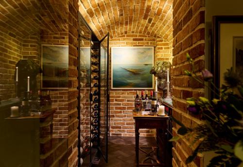 a brick hallway with a table and a painting on a brick wall at Killarney Randles Hotel in Killarney