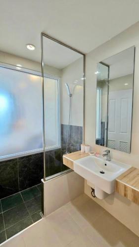 a bathroom with a sink and a shower and a mirror at i-CONDO B2072 in Ban Liap