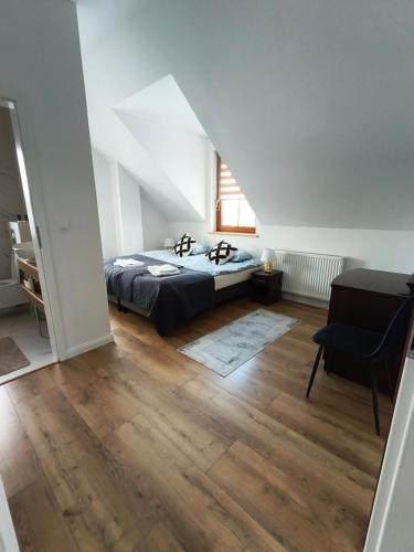 a bedroom with a bed and a chair at Villa Terra in Nałęczów