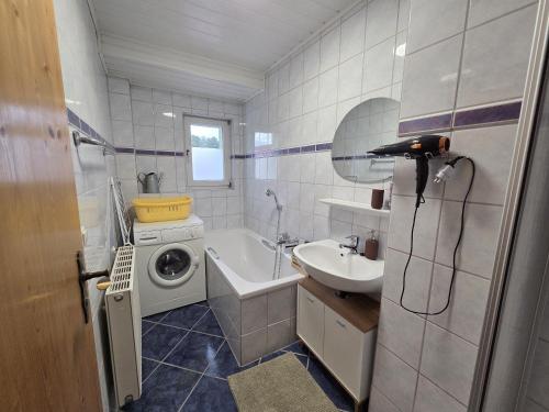 a bathroom with a washing machine and a sink at Ferienwohnung Waldbach in Arrach