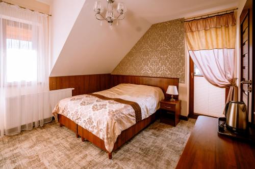 a bedroom with a bed and a chandelier at Aldian Pokoje Gościnne in Szczyrk