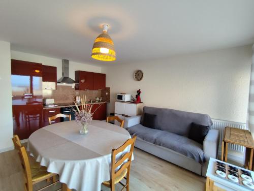 Una sala de estar y una cocina con una mesa y un sofá. en Terre-Mer, en Fort-Mahon-Plage