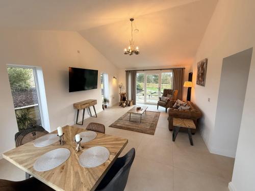 a dining room and living room with a table and chairs at The Farm House in Skipton