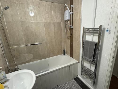 a bathroom with a bath tub and a sink at FilmonHomes in Oldbury