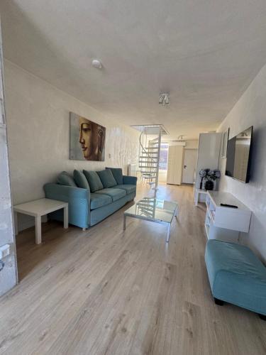 a living room with a blue couch and a table at Studio Jordaan Amsterdam City Centre in Amsterdam