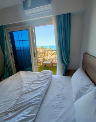 a bedroom with a bed and a view of the ocean at Juliana Beach Hurghada in Hurghada