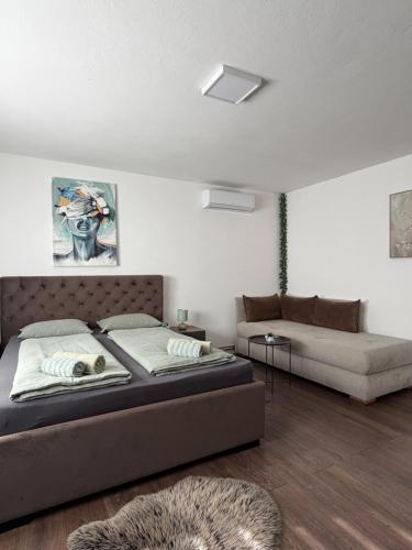 a bedroom with a bed and a couch at Prenoćište Šimić in Slavonski Brod