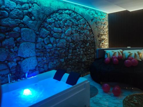 a bedroom with a stone wall and a tub at Suite San Giovanni in Gela