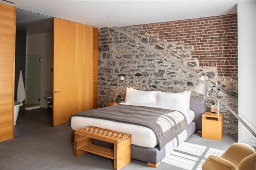 a bedroom with a bed and a brick wall at Hotel Gault in Montreal