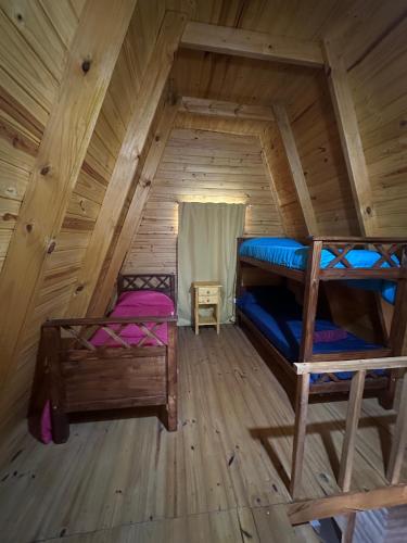a room with two bunk beds in a cabin at Ventana al Champaqui in Yacanto