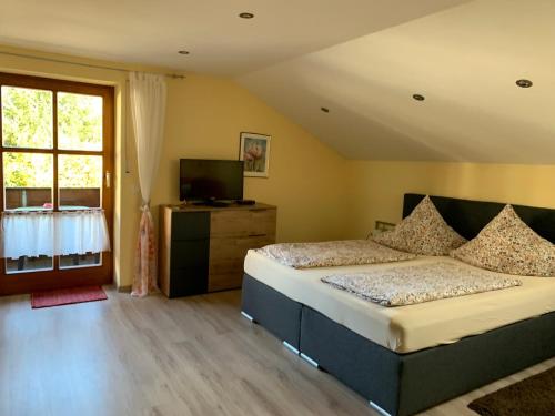 a bedroom with two beds and a large window at Ferienwohnungen Kasparbauer in Regen