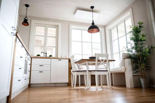 a kitchen with a table and chairs and windows at Glückskind in Neukieritzsch