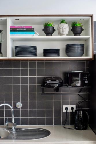 a kitchen counter with plates and plants on a shelf at Villa Alvor in Alvor