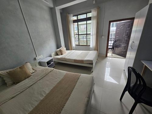 a bedroom with two beds and a window at Seasons Hotel in Lunglei