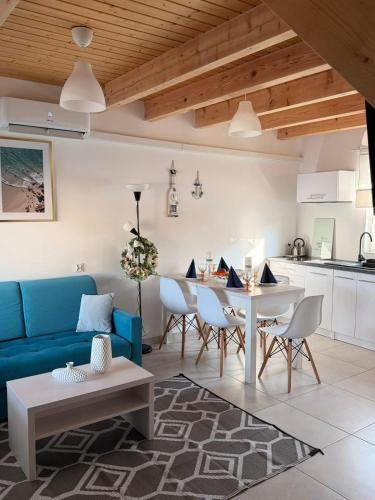 a living room with a blue couch and a table at Białe Domki Paula SPA Niechorze in Niechorze