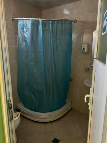 a bathroom with a shower with a blue shower curtain at Villa Jakos Paradise in Batumi