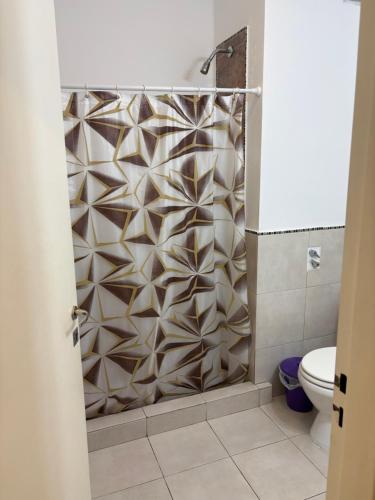 a shower curtain in a bathroom with a toilet at Amelia 2-1 in Villa Carlos Paz