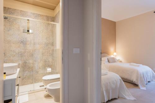 a bathroom with a bed and a toilet and a sink at Casa Scioli in Caraglio