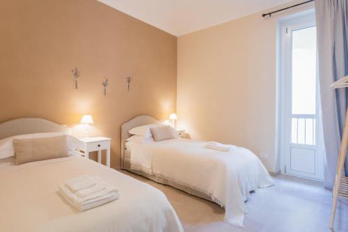 two white beds in a room with a window at Casa Scioli in Caraglio