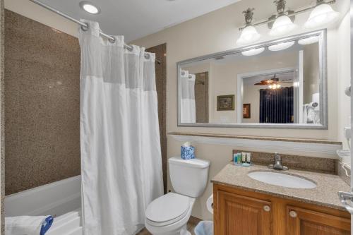 a bathroom with a toilet and a sink and a mirror at Luxury Condo with Huge Private Balcony on Lake Bryan in Orlando