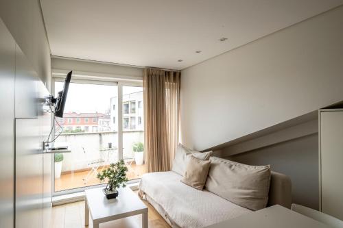 a living room with a couch and a large window at Terro Collection - Alcaide in Braga