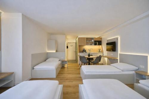 a room with three beds and a kitchen at Evermore Nürnberg - Fürth in Fürth