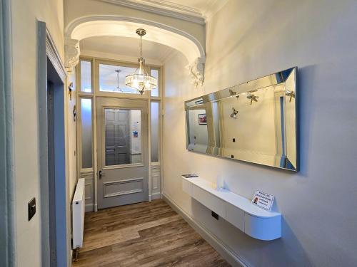 a bathroom with a sink and a mirror and a door at The Harbour House - Deluxe Town Centre Property in Rothesay