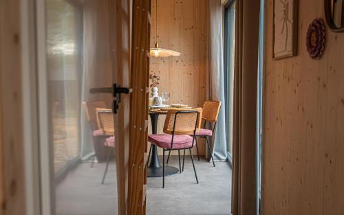 a dining room with a table and chairs in a room at Tinyhouse luxe met privé hottub in Meerssen