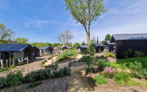 a garden with a row of houses at Tinyhouse luxe met privé hottub in Meerssen