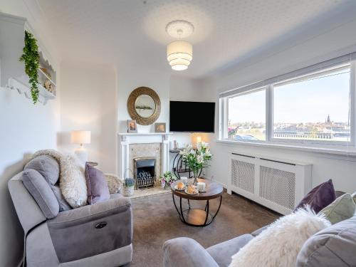 a living room with a couch and a fireplace at Sunrise Cottage in Berwick-Upon-Tweed