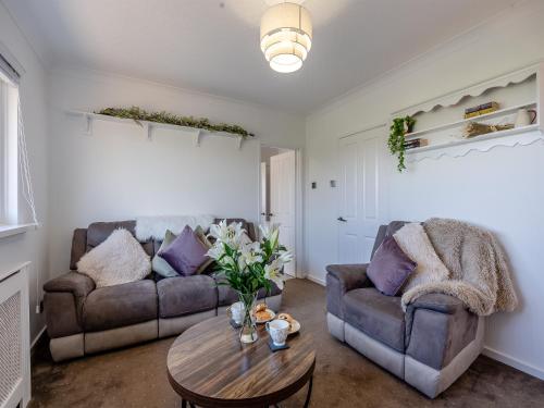 a living room with two couches and a table at Sunrise Cottage in Berwick-Upon-Tweed