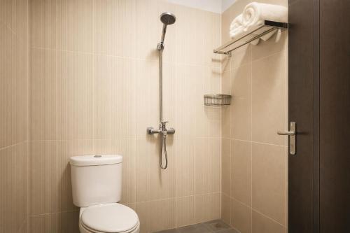 a bathroom with a toilet and a shower at Cahaya Adrian Hotel in Labuan Bajo