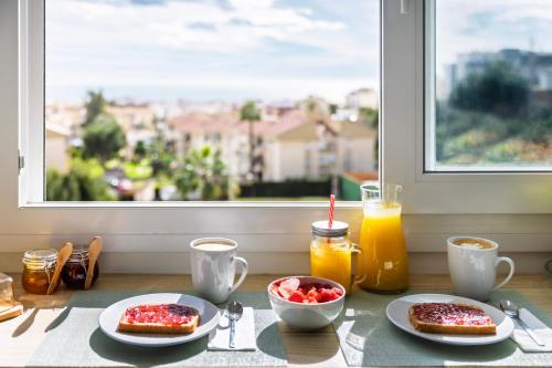 a table with two plates of food and a window at Gran Sol 3BR - Sea View - AC & Wifi - 10 min to Beach in Rincón de la Victoria