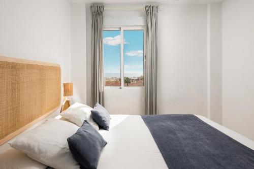 a bedroom with a large bed and a window at Gran Sol 3BR - Sea View - AC & Wifi - 10 min to Beach in Rincón de la Victoria