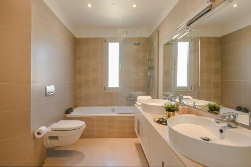 a bathroom with two sinks and a toilet and a tub at Villa Felicity in Svoronata