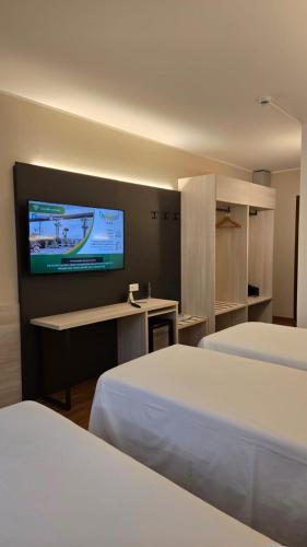 a hotel room with two beds and a flat screen tv at Orzihotel in Orzivecchi