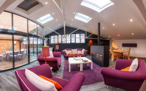 Extra Loft design hyper-centre terrasse في بيتون: غرفة معيشة بها كراسي أرجوانية ومدفأة