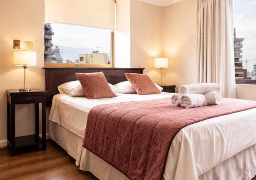 a hotel room with two beds and a window at Apartamentos Costanera Centre in Santiago