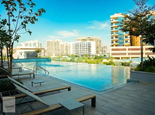 a large swimming pool in a city with buildings at Elegant Haven by Meraki - New 1 Bed Garden View in Dubai