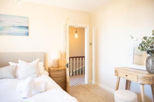 a bedroom with a bed and a desk at Northern Hideaways, Darling Cottage in Seahouses