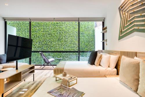 a living room with a bed and a large window at M217 Polanco by Zen Living in Mexico City