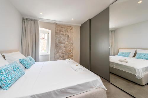 a bedroom with two beds and a mirror at Riva Lavanda Hvar, Old Town in Hvar